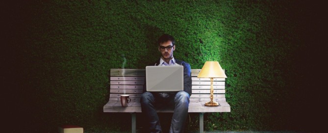 Mann am Laptop auf der Bank